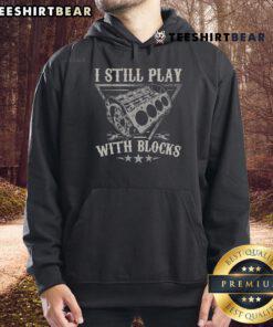 Child playing with blocks in a car mechanic hoodie, showcasing creativity and passion for motor engineering.