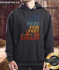 Alt Text: Good Pilates instructor in hoodie demonstrating feet-in-straps exercise for fitness lovers in a gym setting.