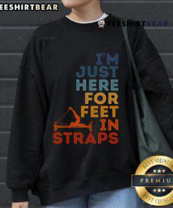 Good Pilates instructor in a cozy sweatshirt, showcasing feet in straps during a gym exercise for fitness lovers.
