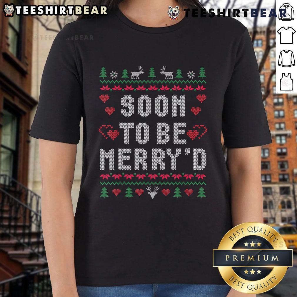 Couple wearing matching ugly Christmas tees, celebrating their soon-to-be engagement in festive holiday spirit.