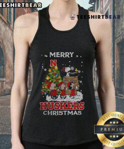 Alt Text: Official Nebraska Cornhuskers Snoopy and Friends Merry Christmas tank top featuring festive design and team colors.