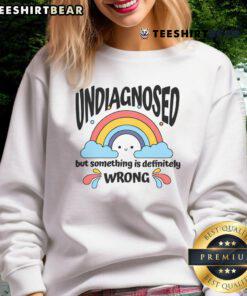 Adorable rainbow sweatshirt with 'Undiagnosed But Something Is Definitely Wrong' text, perfect for quirky fashion lovers.