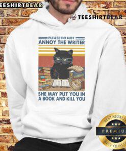 Funny cat hoodie with text 'Please Do Not Annoy The Writer, She May Put You In A Book' perfect for writers and cat lovers.
