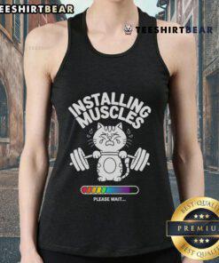 Cat wearing a gym fitness tank top, humorously showcasing 'Good Installing Muscles, Please Wait' during a workout.