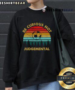Vintage sunset sweatshirt featuring 'Be Curious, Not Judgmental' inspirational football design.