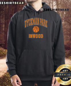Person wearing an orange hoodie playing basketball at Dyckman Park, Inwood, with vibrant park scenery in the background.