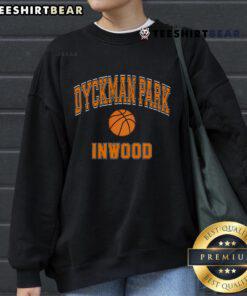 Person wearing an orange sweatshirt at Dyckman Park, Inwood, playing basketball in a vibrant outdoor setting.