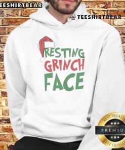 Cozy Christmas hoodie featuring a top-resting Grinch face design, perfect for holiday festivities and winter wear.