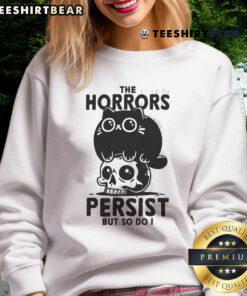 Alt Text: Cute cat graphic on a 'The Horror Persists But So Do I' skull sweatshirt, perfect for cat lovers and edgy fashion.