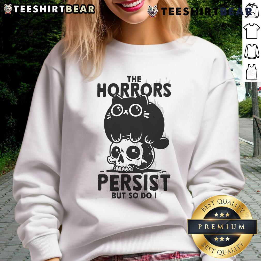 Alt Text: Cute cat graphic on a 'The Horror Persists But So Do I' skull sweatshirt, perfect for cat lovers and edgy fashion.