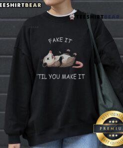 Funny opossum sweatshirt featuring 'Fake It Till You Make It' design, perfect for cute animal lovers and cozy fashion.