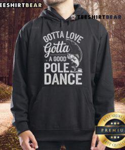 Fisherman wearing a 'Gotta Love a Good Pole Dance' hoodie while fishing by a serene lake, showcasing humor and passion for angling.