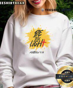 Cozy sweatshirt featuring 'Be the Light' Matthew 5:14 Bible verse design, perfect for Christian apparel enthusiasts.