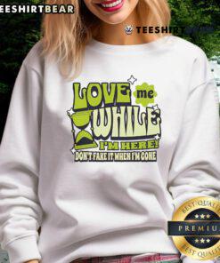 Alt Text: Cozy sweatshirt featuring the phrase Good Love Me While I'm Here, Don't Fake It When I'm Gone for heartfelt fashion.