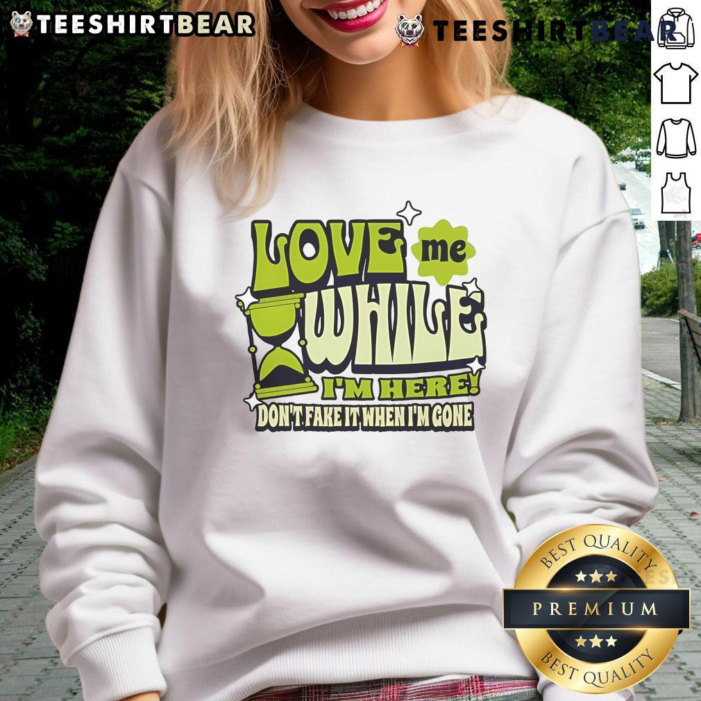Alt Text: Cozy sweatshirt featuring the phrase Good Love Me While I'm Here, Don't Fake It When I'm Gone for heartfelt fashion.