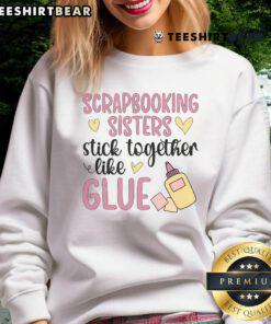Two sisters wearing matching 'Good Scrapbooking Sisters' sweatshirts, showcasing their love for scrapbooking together.