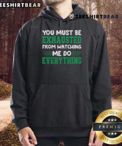 Cozy 'Good You Must Be Exhausted From Watching Me Do Everything' hoodie displayed on a mannequin in a stylish setting.