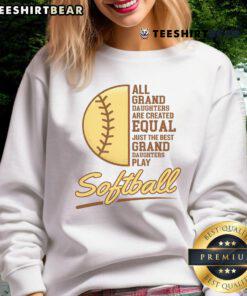 Happy grandparent wearing a sweatshirt that says 'My Granddaughter Plays Softball' at a softball game.