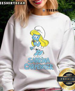 Sabrina Carpenter wearing a stylish Smurfs sweatshirt, showcasing her trendy fashion sense and vibrant personality.
