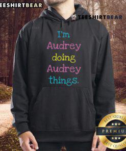 Audrey wearing a 'Nice I'm Audrey' hoodie, showcasing her unique style and personality in a vibrant setting.