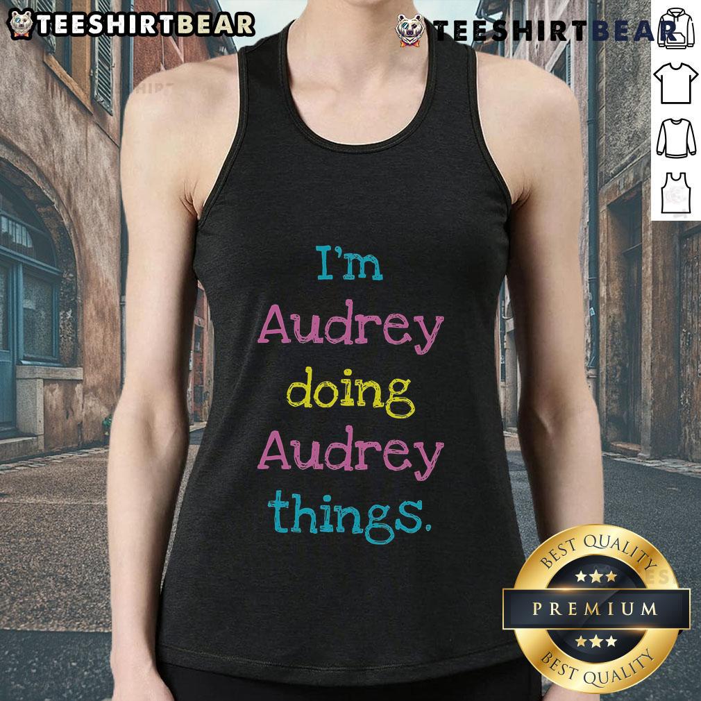 Audrey wearing a stylish tank top, smiling while enjoying her favorite activities outdoors in a sunny setting.