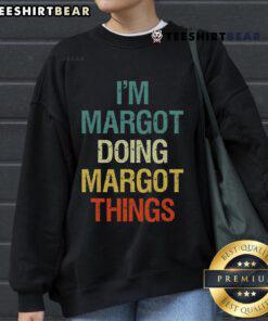 Margot wearing a vintage retro sweatshirt, showcasing her unique style and personality in a charming setting.