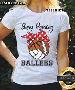 Official Busy Raising Ballers ladies tee featuring volleyball, football, and basketball graphics for sports enthusiasts.
