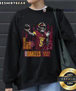 Jayden Daniels wearing a black Washington Commanders sweatshirt, celebrating his 2024 NFL Offensive Rookie of the Year honor.