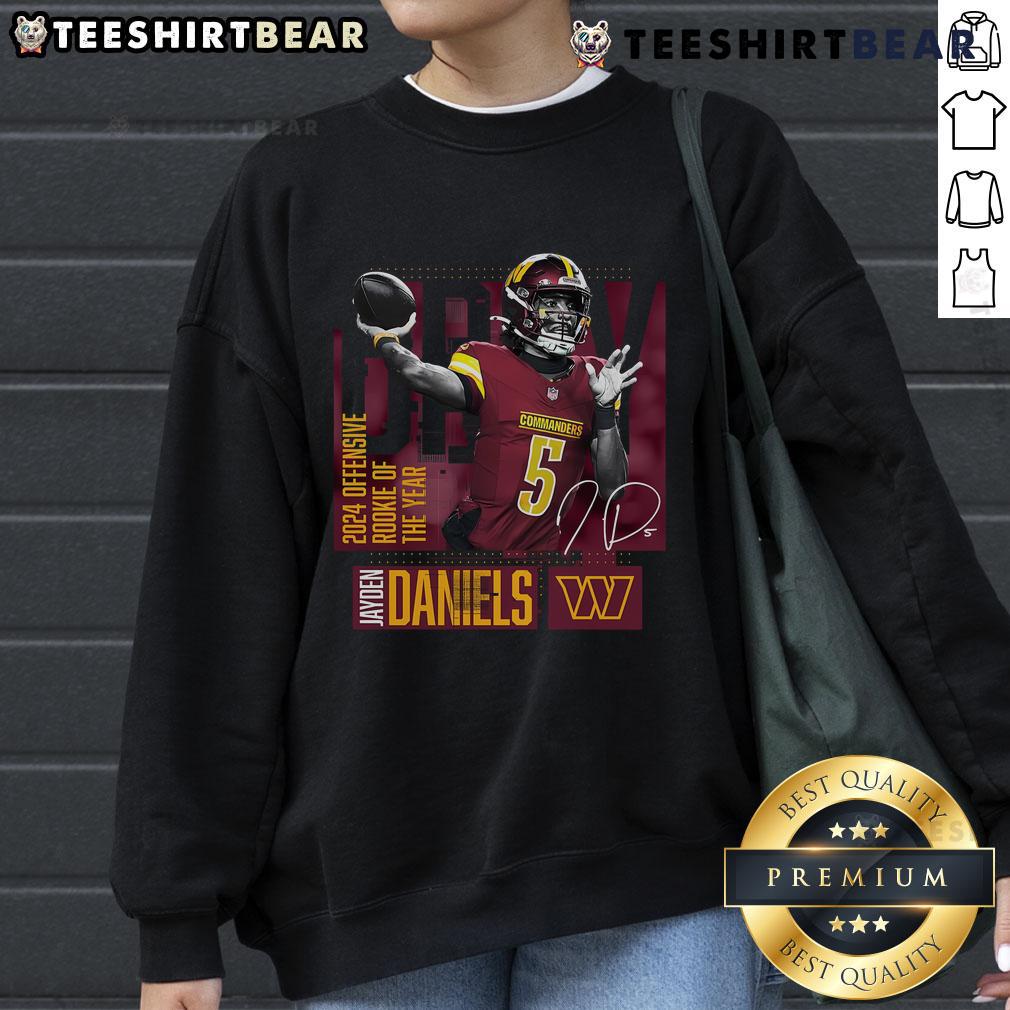 Jayden Daniels wearing a black Washington Commanders sweatshirt, celebrating his 2024 NFL Offensive Rookie of the Year honor.