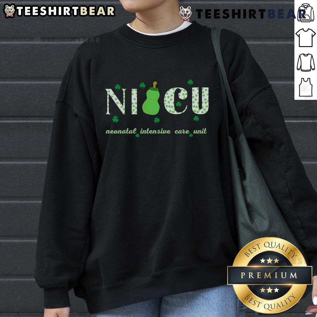 Happy NICU nurse in a retro shamrock sweatshirt celebrating St. Patrick's Day with a cheerful smile.