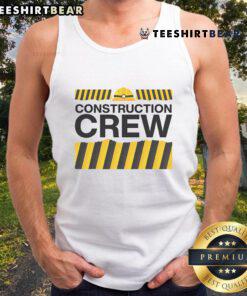 Good construction crew and highway workers in matching tank tops celebrate teamwork at a construction site.