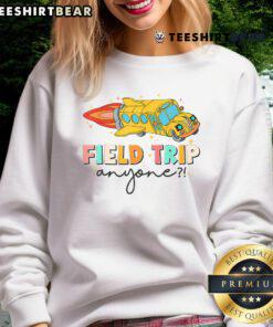Teachers wearing 'Nice Field Trip Anyone' sweatshirts at a fun field day event, enjoying outdoor activities and teamwork.