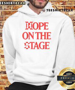 Person wearing a Nice Hope On The Stage hoodie, showcasing stylish design and vibrant colors at a live event.