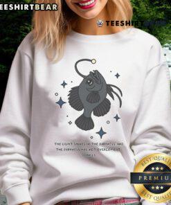 Christian angler fish sweatshirt featuring 'Nice Light Shines in Darkness' Bible verse for faith-inspired fashion.