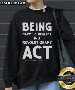 Top Being Happy and Healthy is a Revolutionary Act sweatshirt displayed on a hanger, promoting wellness and positivity.