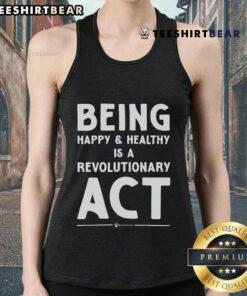 Model wearing a tank top with 'Being Happy and Healthy is a Revolutionary Act' slogan, promoting wellness and positivity.