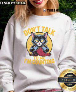 Funny cat in a knitting-themed sweatshirt saying 'Don't talk to me, I'm counting' for knitting lovers.