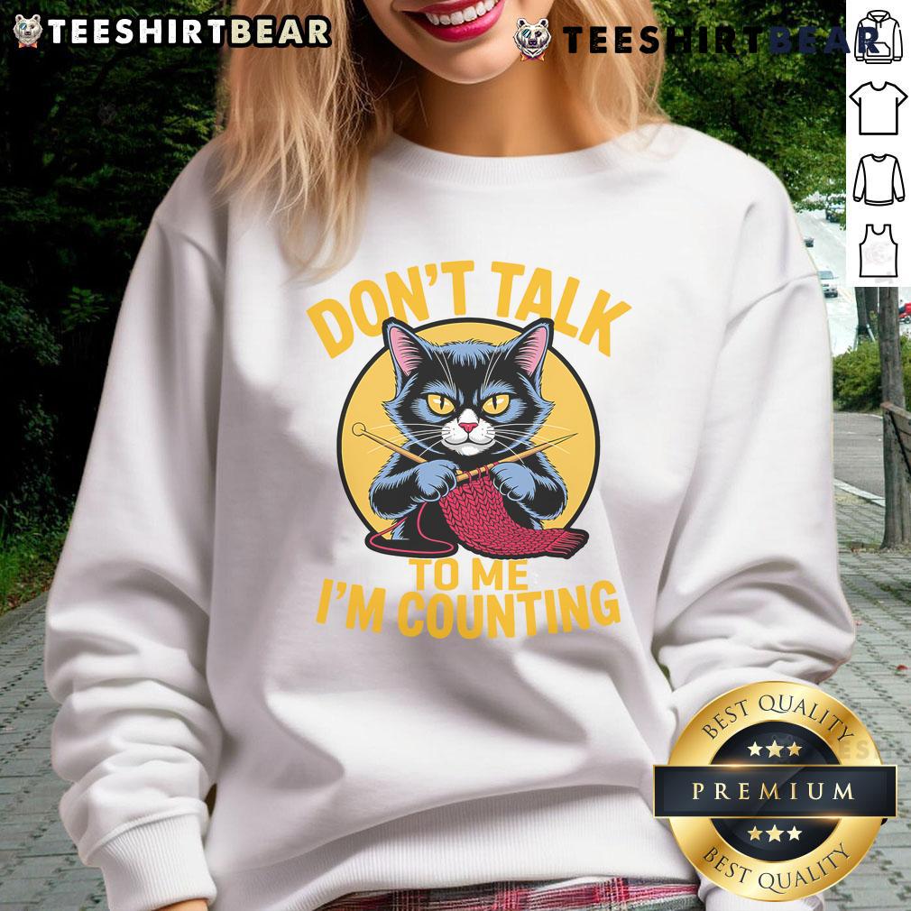 Funny cat in a knitting-themed sweatshirt saying 'Don't talk to me, I'm counting' for knitting lovers.