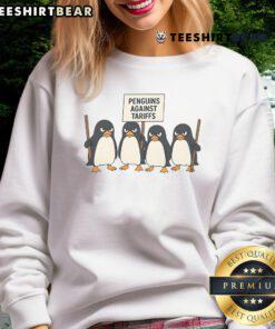 Funny penguins protesting against tariffs on a colorful sweatshirt design featuring cartoon penguins.