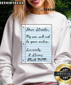 Strong Black mom wearing 'My Son Will Not Be Your Victim' sweatshirt, walking on a nice street with confidence.