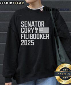 Senator Cory Booker wearing a 'Cory Filibooker' sweatshirt during a speech, showcasing his advocacy and style.