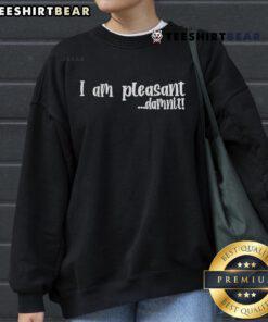 Top I Am Pleasant Damnit Sweatshirt displayed on a wooden table with casual styling, perfect for cozy outfits.