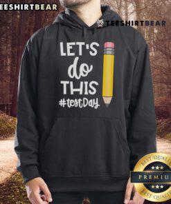 Teacher wearing a motivational hoodie for state testing, promoting positivity with 'Let's Do This Test Day' message.