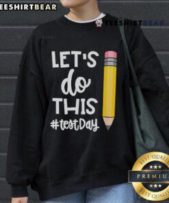 Teacher wearing a motivational sweatshirt for state testing day, inspiring students with 'Let's Do This' message.
