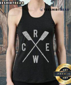 Top rowing crew with crossed oars, rowers in tank tops, coached by a dedicated team leader on the water.