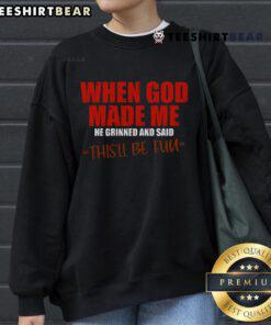 Alt Text: Premium sweatshirt featuring the quote When God Made Me, He Grinned and Said, This'll Be Fun in stylish typography.