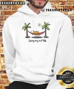 Cute cat lounging in a cozy hoodie, embodying the spirit of living its best life in a warm, playful atmosphere.