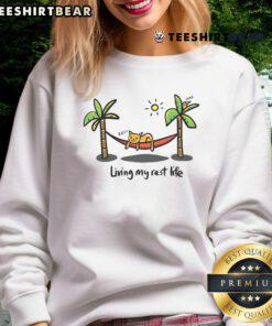 Alt Text: Cute cat lounging in a cozy sweatshirt, embodying the 'Living My Rest Life' vibe for ultimate comfort.