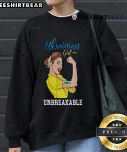 Ukrainian girl in a messy bun wearing a Ukraine sweatshirt, proudly displaying the Ukrainian flag.
