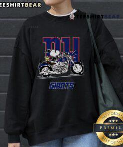 Alt Text: Snoopy and Woodstock riding a motorbike in a New York Giants sweatshirt, showcasing playful cartoon style and team spirit.